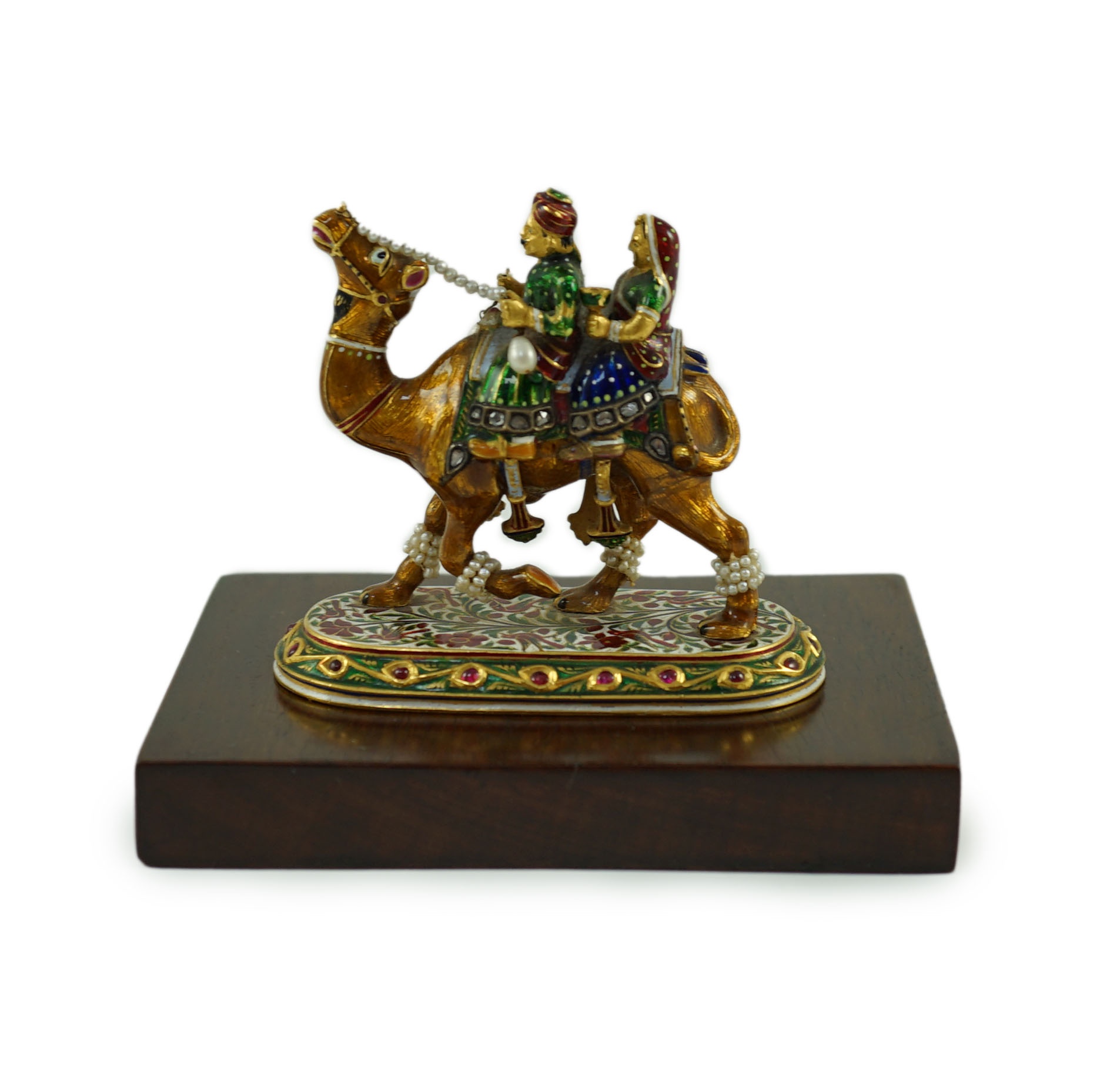 A 20th century Indian Mughal style gold, polychrome enamel, diamond, seed pearl and cabochon ruby set miniature model of a camel with two riders, on oval base